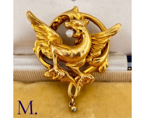 A Chimera Brooch in yellow gold, designed as a chimera within a scrolling border set to the mouth with a pearl. Size: 4.1cm W