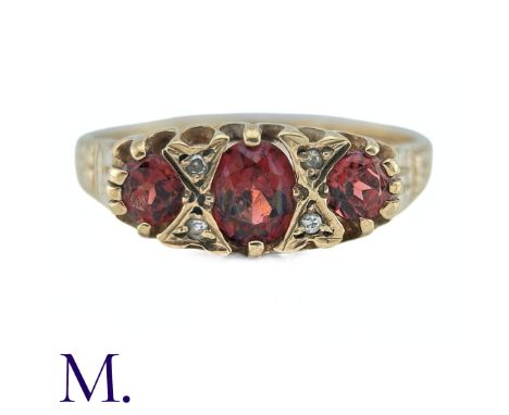A Garnet and Diamond Ring, in 9k yellow gold, the three oval cut Garnets punctuated by pairs of round cut diamonds. Hallmark 