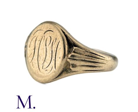 A Signet Ring in 9k yellow gold, the oval shaped face engraved with a moniker, fluted decoration to bezel. Full British Hallm