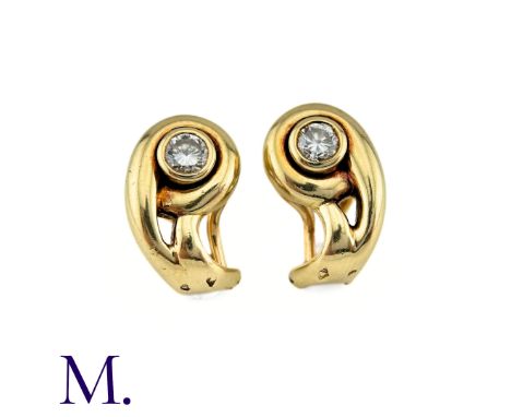 A Pair Of Cartier Diamond Earrings in 18k yellow gold of scrolling design, each set with a diamond of approximately 0.20cts. 