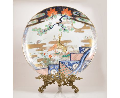 A Japanese porcelain charger, perhaps Meiji period, decorated with a stag and doe, flowers and foliage in an Imari palette, d