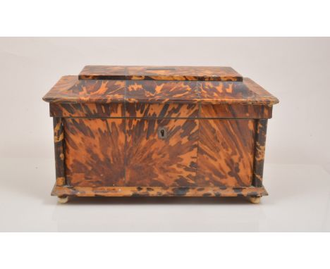 A Regency tortoiseshell sarcophagus shape tea caddy, rectangular hinged lid, the base with engaged columns to the canted corn