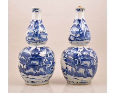 A pair of Chinese blue and white double gourd shape vases, bearing Kangxi four character mark, painted with landscape scenes,