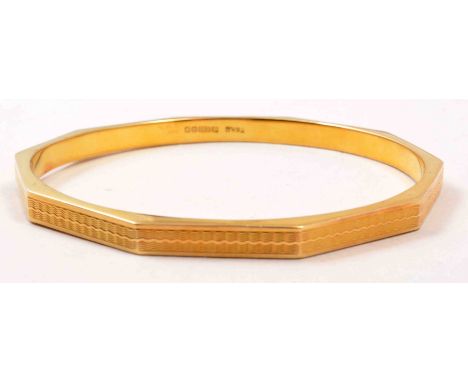 A 15ct hallmarked gold 5.8mm wide ten sided engine turned bangle, Birmingham 1928, 15grms.