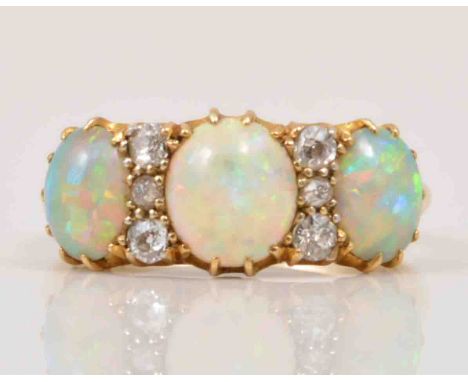 An Edwardian opal and diamond half hoop ring, three oval cabochon cut opals, spaced by six old cut diamonds, yellow metal mou