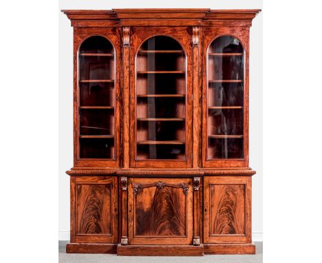 A Victorian mahogany breakfront bookcase, ogee moulded cornice, plain frieze, the upper section with three arched glazed pane