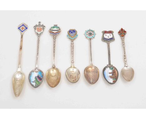 A collection of Edwardian and later silver and enamel souvenir spoons.