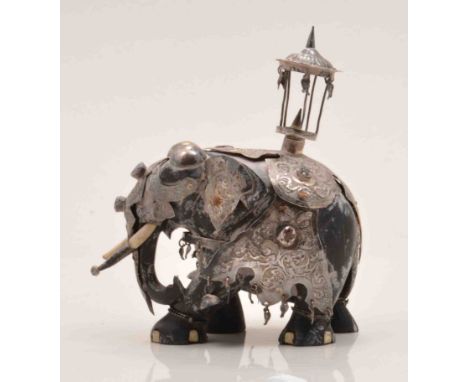 An Indian ebony and white metal model of a processional elephant, probably late 19th Century, with ivory tusks, set with semi