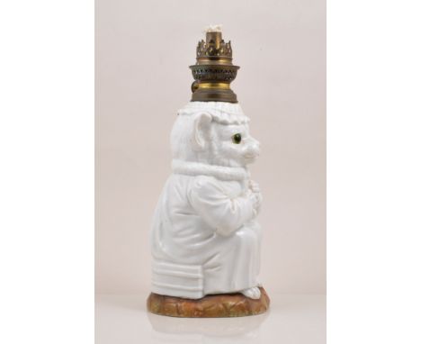 A French porcelain nursery oil lamp, designed as a seated zoomorphic cat, clothed, metal mounts, amethyst tinted overlaid sha