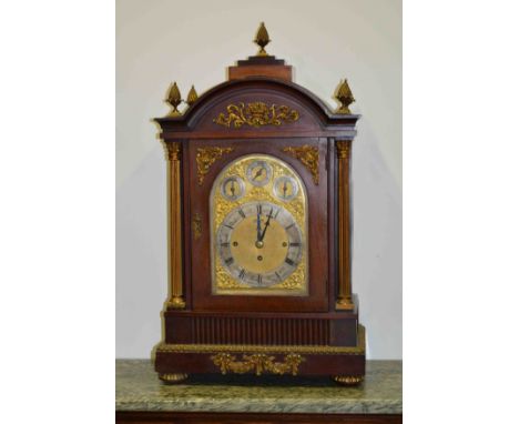 A late Victorian mahogany bracket clock, gilt metal appliques, urn finials and fluted Corinthian columns, arched brass face w