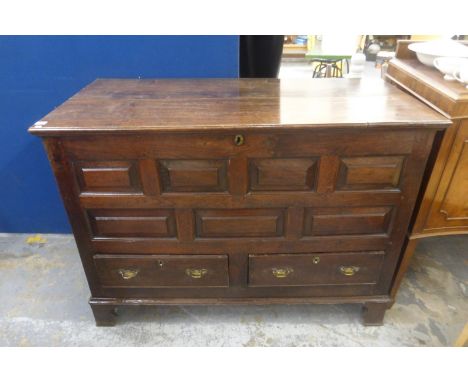 An 18th Century oak mule chest, the rising lid above a panelled front and two drawers to bracket feet. 