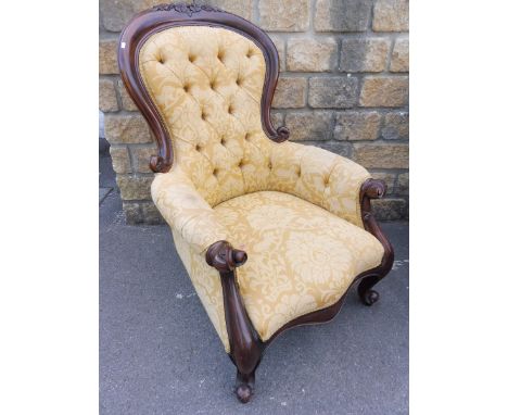A mahogany show wood framed button back armchair raised upon shaped front supports. 