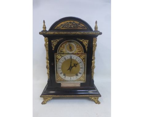 A late Victorian ebonised and gilded metal mounted mantle clock with presentation plaque.
