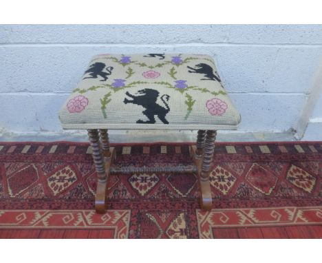 A Victorian stool, the tapestry upholstered top raised upon bobbin turned rosewood supports joined by a cross stretcher.