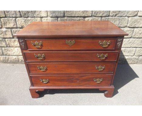 A George III style mahogany chest of four long drawers with brass handles raised upon bracket feet.