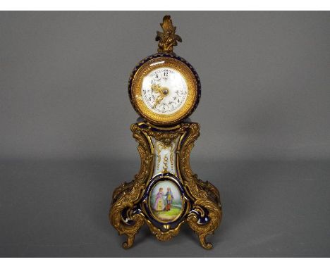 A Sevres style porcelain cased desk clock with metal mounts, decorated with a panel of a courting couple and floral swags, ap