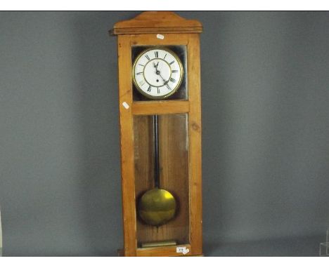 A pine cased wall clock, approximately 90 cm x 31 cm.