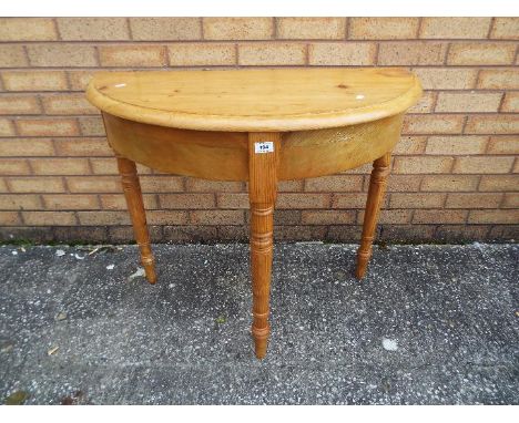A pine demi lune console table measuring approximately 72 cm x 86 cm x 43 cm.
