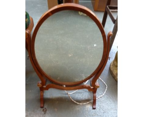 A toilet mirror with oval mirror glass, together with a turned wood standard lamp and shade