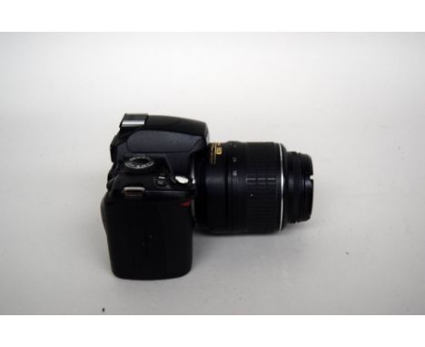 A Nikon D60 35mm digital camera with 18-55mm Nikon lens with battery charger, accessories and strap