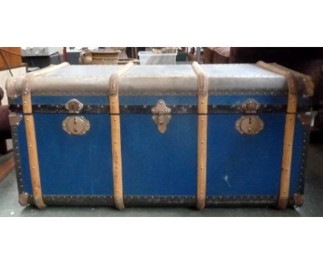 A substantial travelling trunk with metal and wood bands, leather handles and original travel labels, 50 x 50 x 112cmH