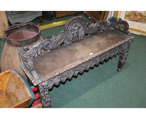 Oak hall bench, with mask and scroll carved back, on silhouette carved legs
