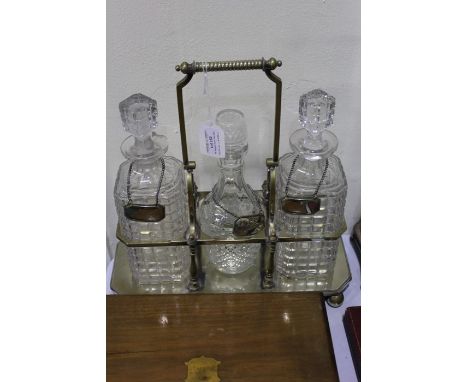 Plated tantalus containing three decanters and with three decanter labels for whiskey, brandy and gin