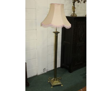 Brass corinthian column standard lamp, raised on a square plinth base and paw feet