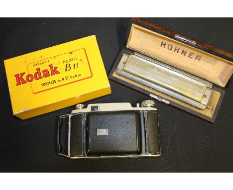 Hohner 64 Chromonica harmonica, housed in a maple effect case,  Kodak Modele B11 camera, housed in original box