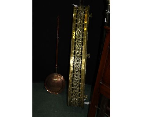 Brass fender, with pierced front rail, raised on paw feet, 120cm wide, copper warming pan with turned wooden handle (2)