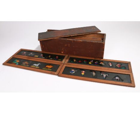 Twelve magic lantern slides, to include two with moving actions and ten comic slides, housed in a wooden box with sliding lid