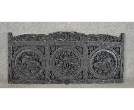 A Chinese carved hardwood panel, the top rail with two fragons flanking a flaming pearl, over three roundels depicting a drag