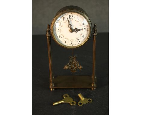 An early 20th century French gilt metal mantle clock with white enamel dial with rose swag decoration. The pendulum modelled 