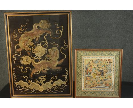 Two framed and glazed 19th century silk embroideries. One with gold thread on a black ground depicting two dragons chasing a 