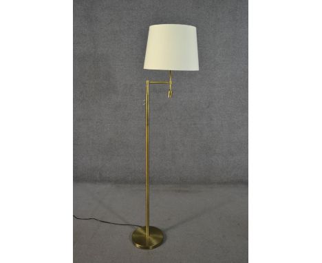 A 20th century brushed brass floor lamp with swing arm and cream shade. H.157cm 