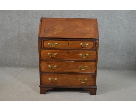 A George III mahogany bureau, of narrow proportions, the fall front enclosing pigeonholes and two rows of four short drawers,