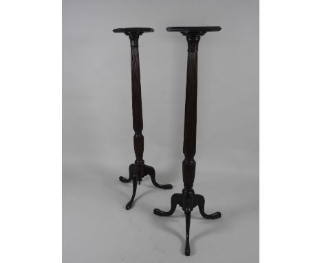 A pair of mahogany bedpost torcheres with octagonal tops on slender octagonal reeded columns and tripod base 131.5cm high, 
(