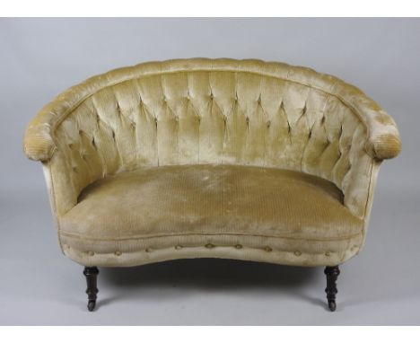 A Victorian upholstered curved linear two seater sofa on ring turned tapering short front legs terminating brown salt glazed 