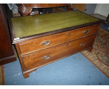 A circa 1900 low green leather inset topped Chest of two long Drawers with brass back plate drop handles and standing on brac