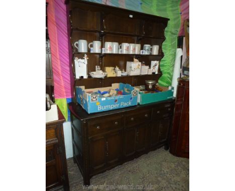 A contemporary Ercol dark Oak Dresser compete with rack, the base with three cupboards and three frieze drawers, 57 1/2'' wid
