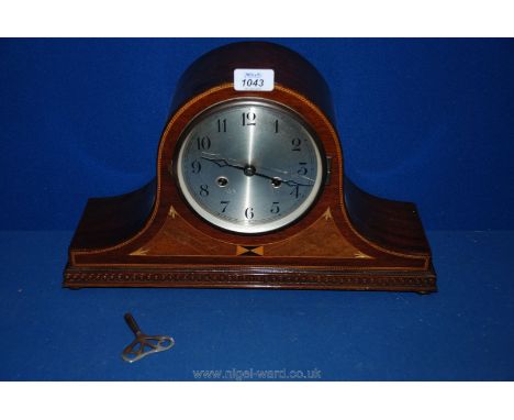 A mantle clock in a marquetry wooden case, with Arabic numerals, a key and pendulum (some scratches).