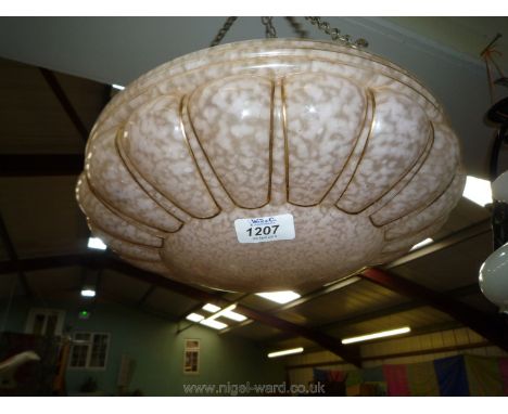 A hanging glass light shade in pink and gold.