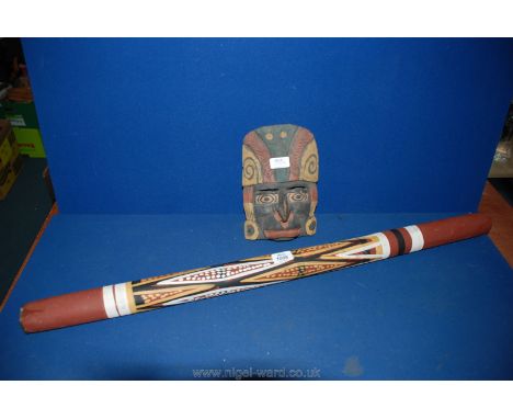 A vintage Didgeridoo and tribal mask.