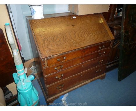 An Oak Bureau, the slope front revealing an interior with drawers, pigeon holes and a small cupboard flanked by reeded pillar