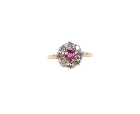An 18ct gold and platinum diamond and ruby flower head ring, the central ruby surrounded by brilliant cut diamonds, approx UK