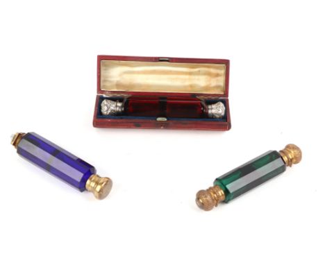 A Victorian silver topped cranberry glass double-ended scent bottle, 12.5cms long, cased; together with two similar gilt meta