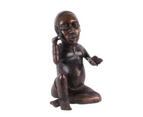 A large antique African bronze figure of a boy holding a book, 34cms high.