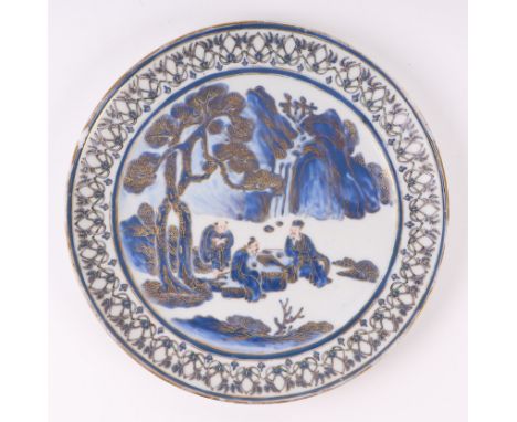 A Chinese blue & white plate decorated with figures playing a board game under a fir tree, with gilt highlights, 25cms diamet