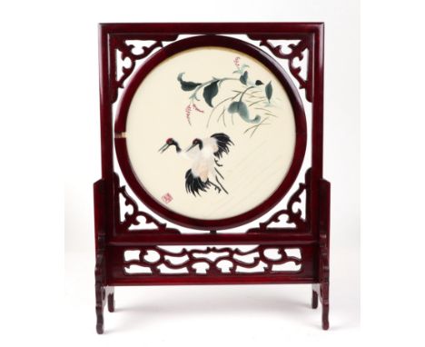 A Chinese hardwood framed table screen, depicting a crane on a cream ground, signed with red character marks, 25cm diameter, 