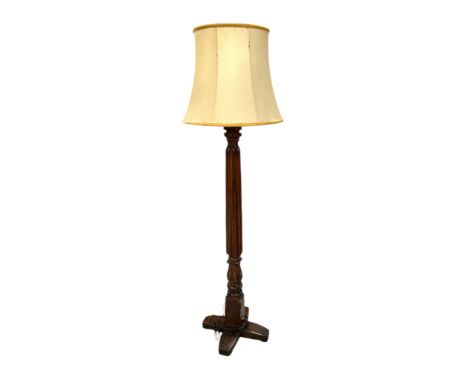 A mahogany standard lamp with carved reeded column, on a quatreform base, 138cms high.